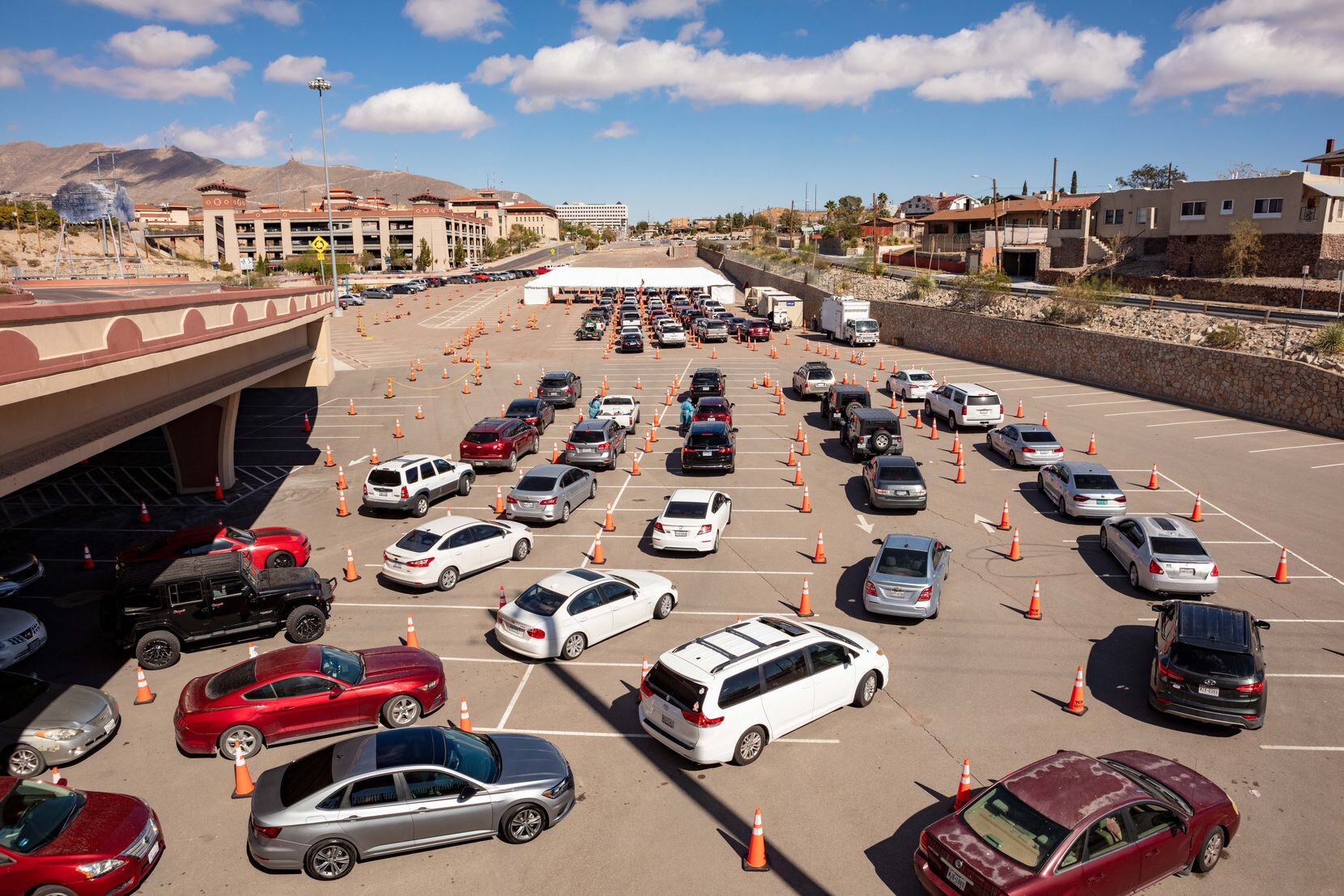 Personas en uutos hacen fila para realizarse exámanes de covid-19 en un estacionamiento de la Universidad de Texas en El Paso.