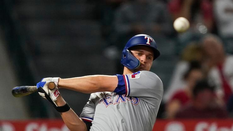 Texas Rangers' Corey Seager hits a foul ball during the third inning of a baseball game...