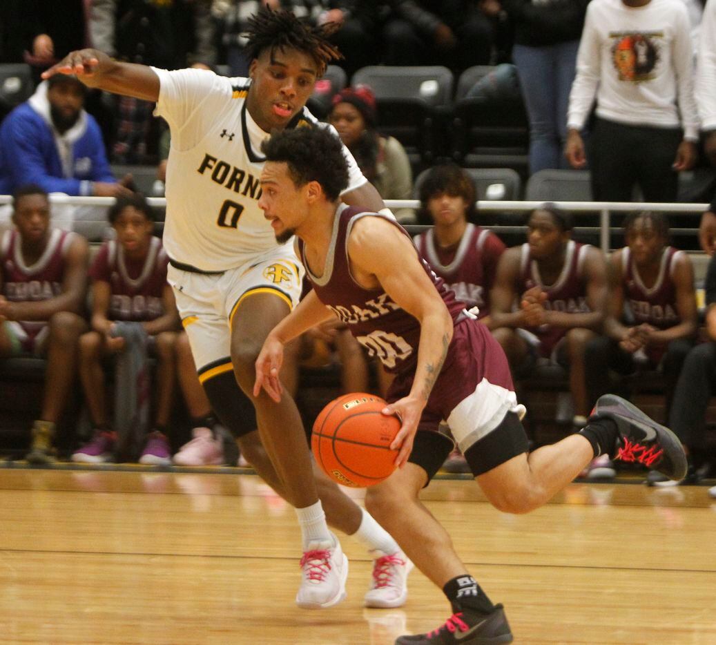 Red Oak guard Mark Broussard (00) drives past the defense of Forney forward Ronnie Harrison...