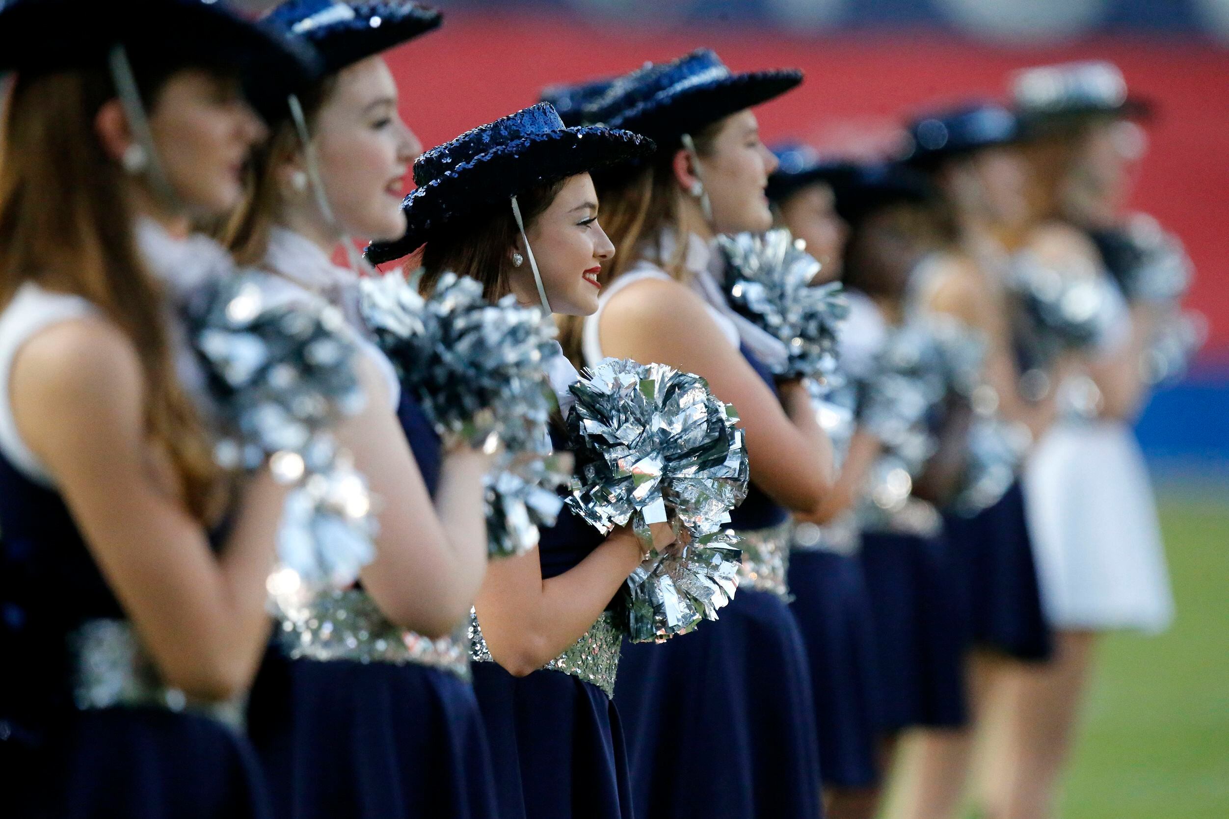 The Lone Star High School Rangerettes drill team stand at attention for the national anthem...