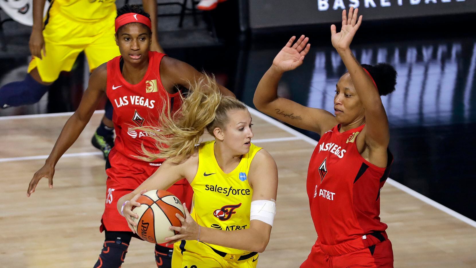 Indiana Fever forward Lauren Cox (13) drives into Las Vegas Aces center A'ja Wilson (22) and forward Angel McCoughtry (35) during the second half of a WNBA basketball game Tuesday, Aug. 11, 2020, in Bradenton, Fla.