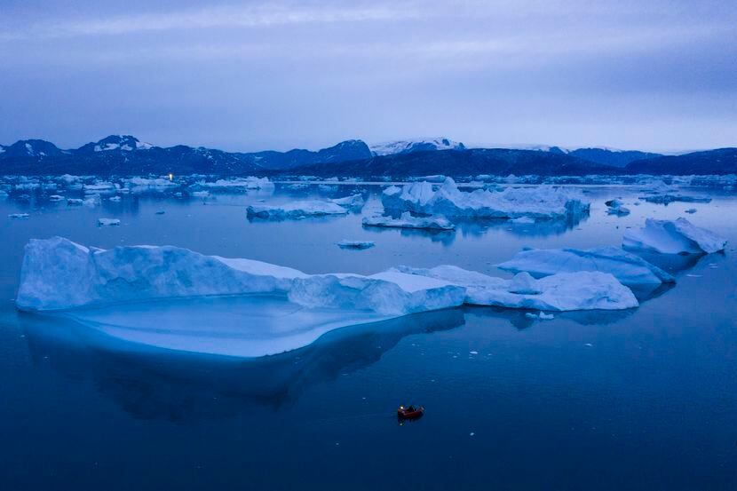 Un bote navega junto a icebergs el 15 de agosto de 2019, cerca de la localidad de Kulusuk,...