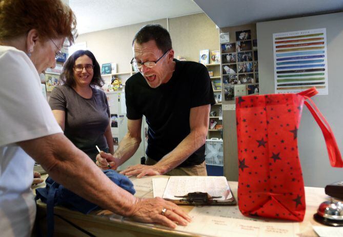 Brian Riggs, a longtime employee of Lucky Dog Books, chats with his customer Louise Kirby,...