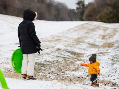 Lauren Jarret, 34, with Wesley Jarret, 1, as they play with sleet near at White Rock Lake in...