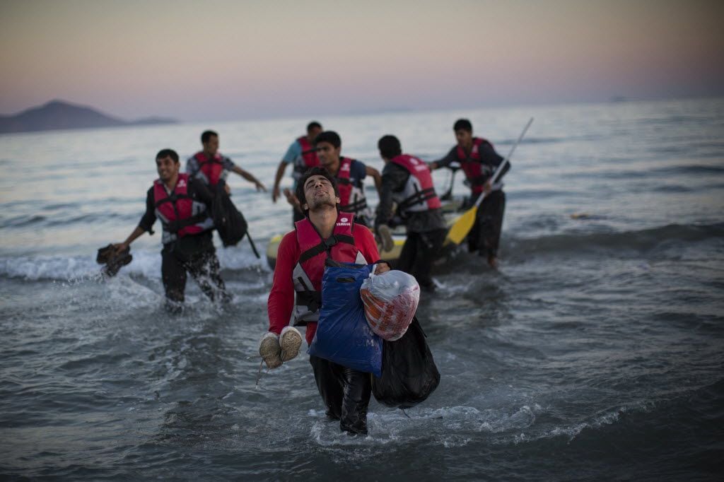 Migrants from Pakistan land on shore after completing a journey in a small dinghy crossing a...