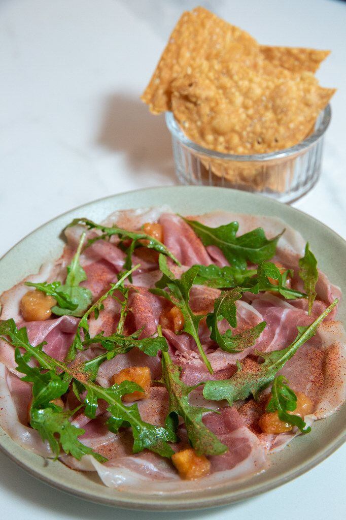 A serving of 26-month prosciutto with peach mostarda, pickled rhubarb, garden arugula and a...