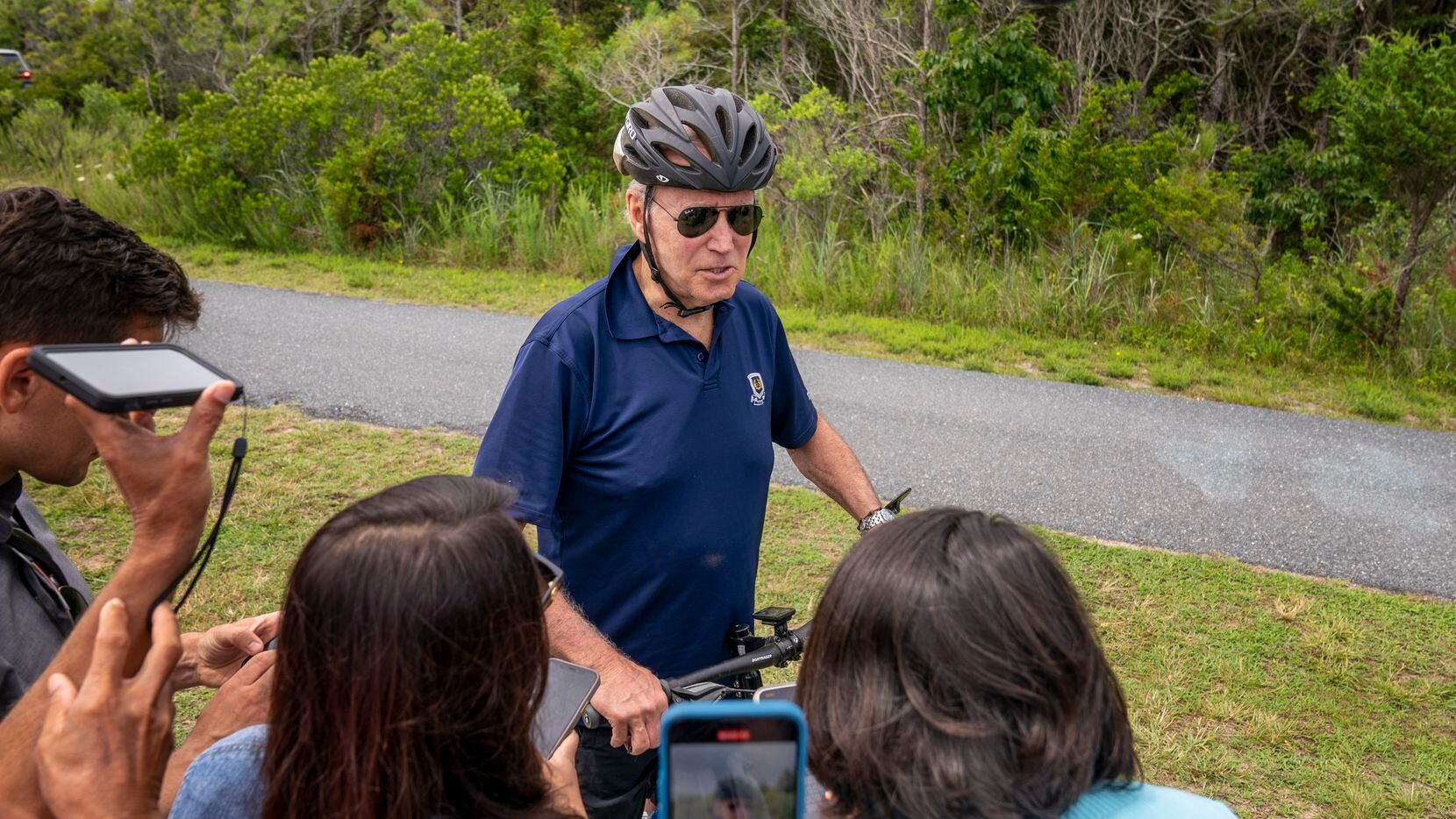 President Joe Biden speaks to members of the media as he goes on a bike ride in Gordons Pond...