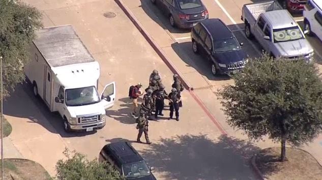 Midlothian police officers in armor gathered near Midlothian High School after a threat was...