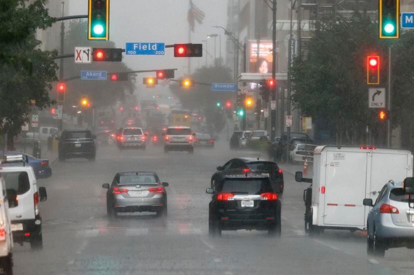 Cars drive along Commerce Street during a thunderstorm in downtown Dallas on Tuesday.