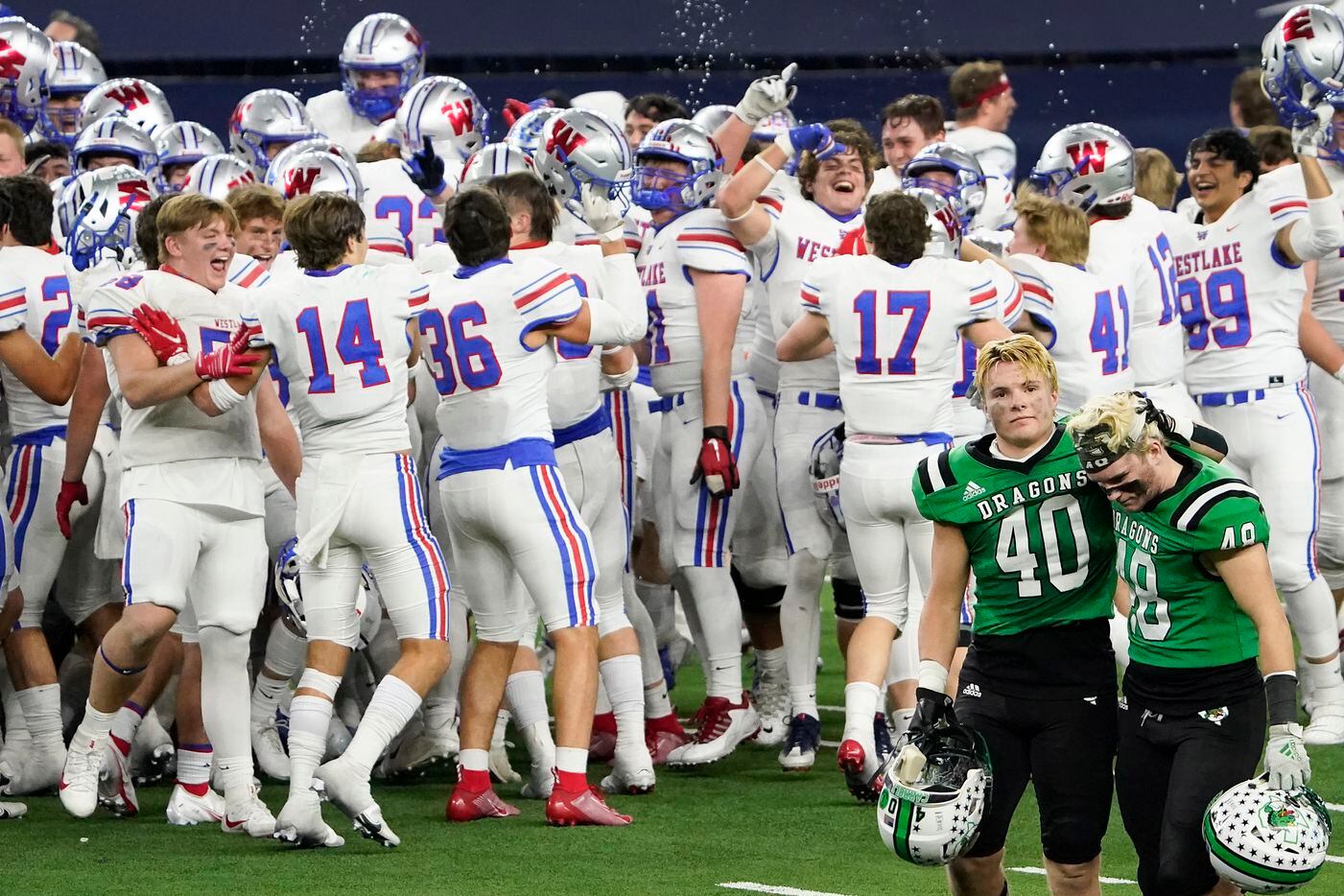 Southlake Carroll linebacker Allan Kleiman (40) consoles linebacker Aiden Peil (48) as the leave the field while Austin Westlake players celebrate after a 52-34 Westlake victory in the Class 6A Division I state football championship game at AT&T Stadium on Saturday, Jan. 16, 2021, in Arlington, Texas. (Smiley N. Pool/The Dallas Morning News)