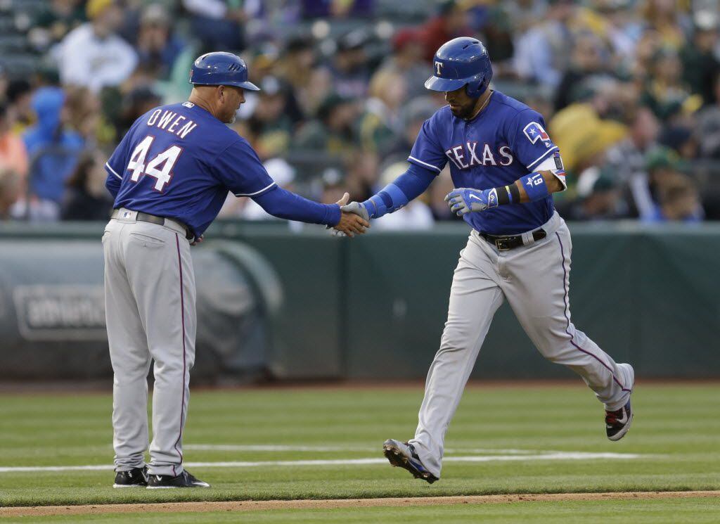 Texas Rangers' Robinson Chirinos, right, celebrates with Spike Owen (44) after hitting a...