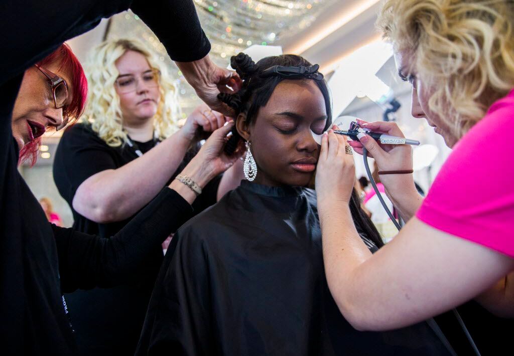 Justin F. Kimball High school student Azyria Hutchins, 17, (center) has her hair and makeup...
