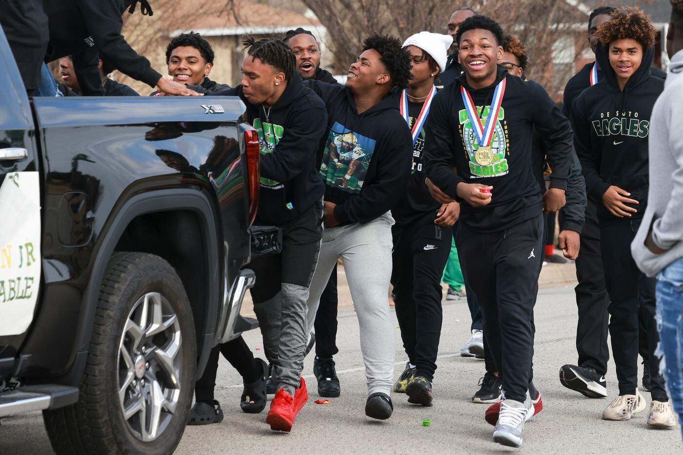 DeSoto High School football players walk down the street near the end of the parade,...
