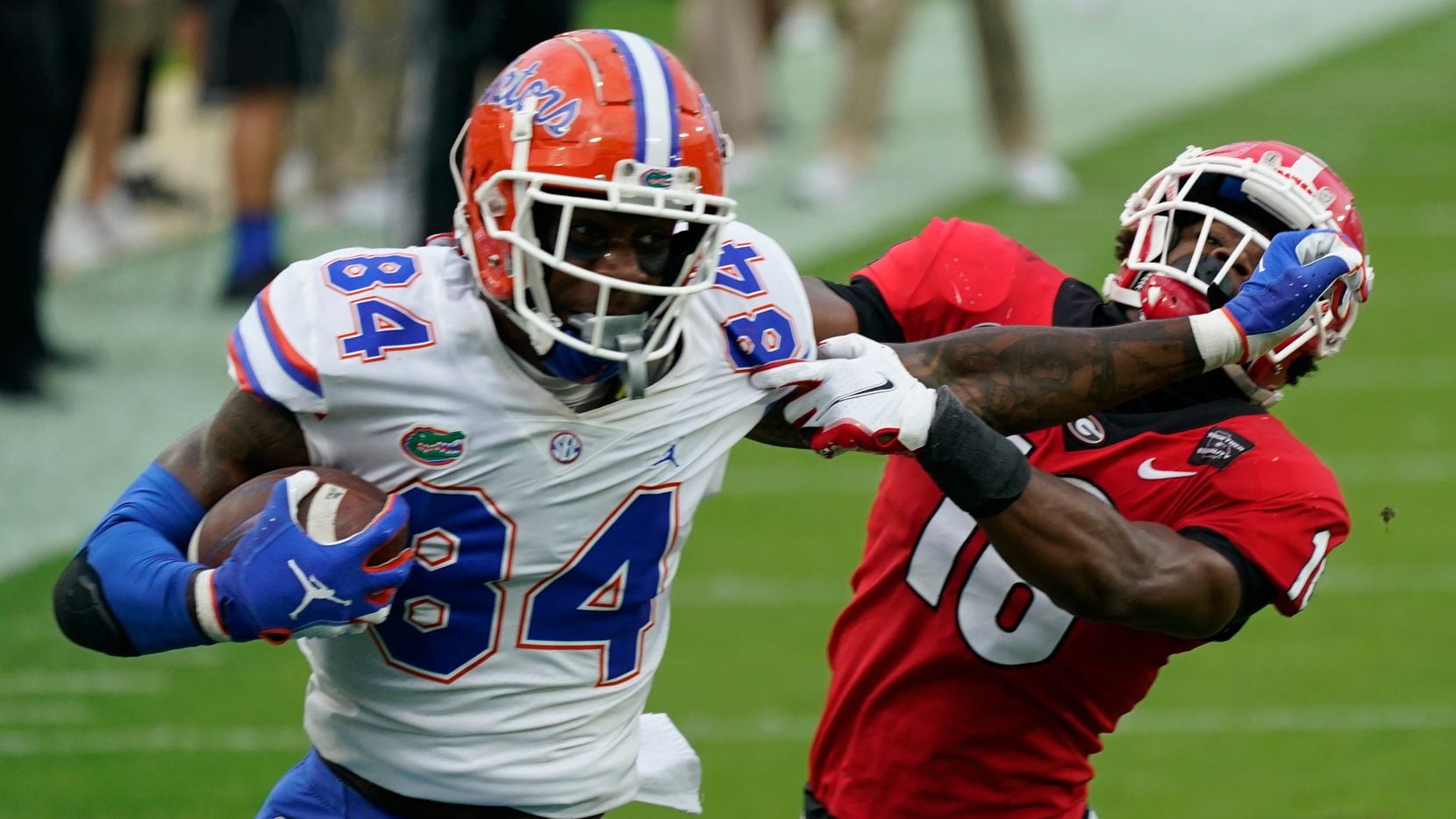FILE - Florida tight end Kyle Pitts (84) tires to get past Georgia defensive back Lewis Cine (16) after a reception during the first half of an NCAA college football game in Jacksonville, Fla., in this Saturday, Nov. 7, 2020, file photo.