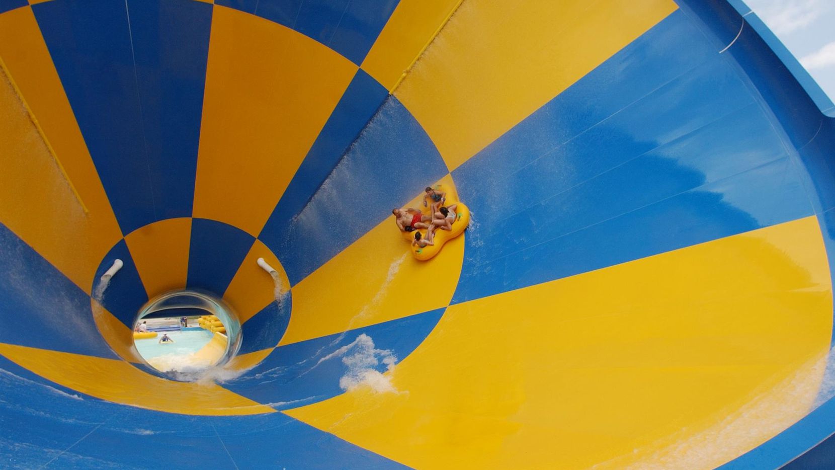 A group slides down the Tornado at Six Flags Hurricane Harbor in Arlington, the largest...