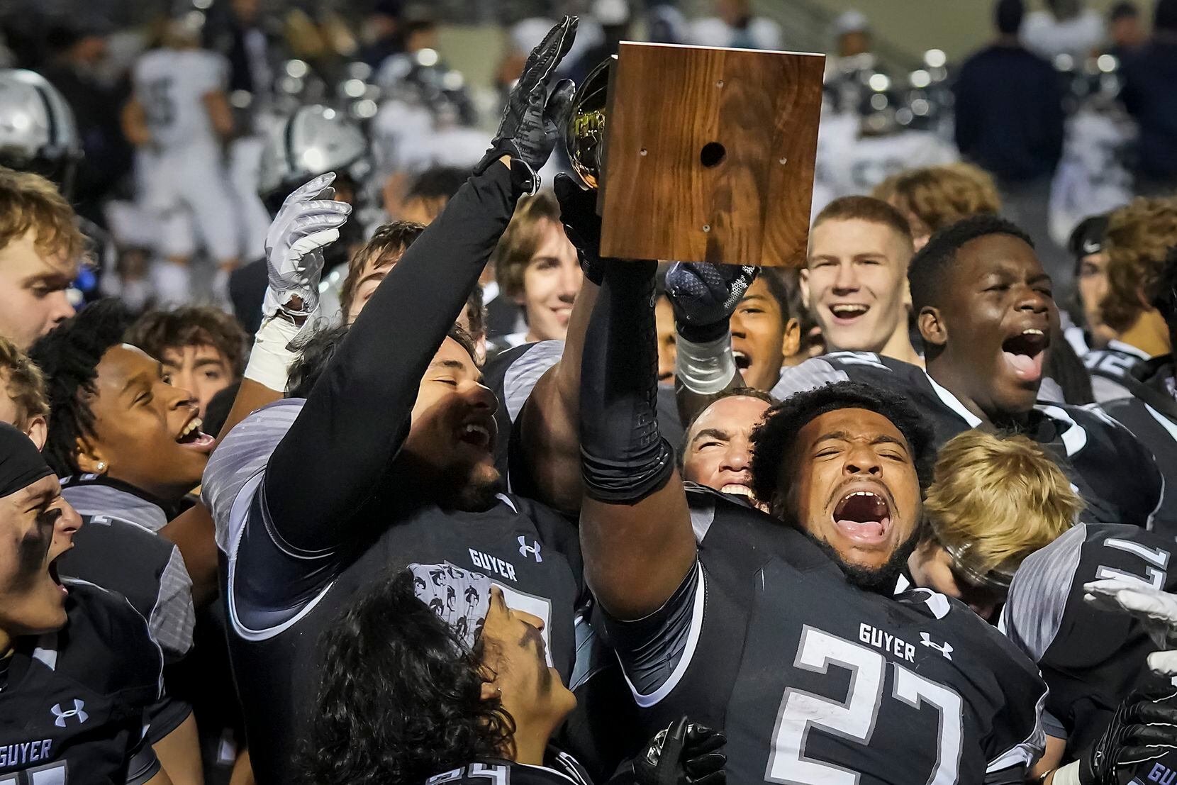Denton Guyer running back Byron Phillips (27) lifts the game trophy after a victory over...