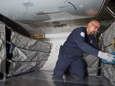 An American Airlines fleet worker loads cargo onto a plane.