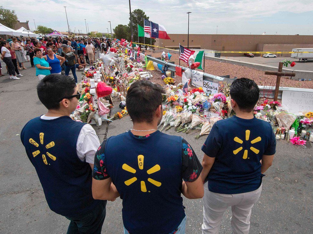 Walmart employees pay their respects at a makeshift memorial for the shooting victims, at the Cielo Vista Mall Walmart in El Paso, Texas, on August 6, 2019. - The August 3 shooting left 22 people dead. US President Donald Trump will visit the Texan border city August 7, and will also travel to Dayton, Ohio where a second mass shooting early August 4 left another nine dead. (Photo by Mark RALSTON / AFP)MARK RALSTON/AFP/Getty Images