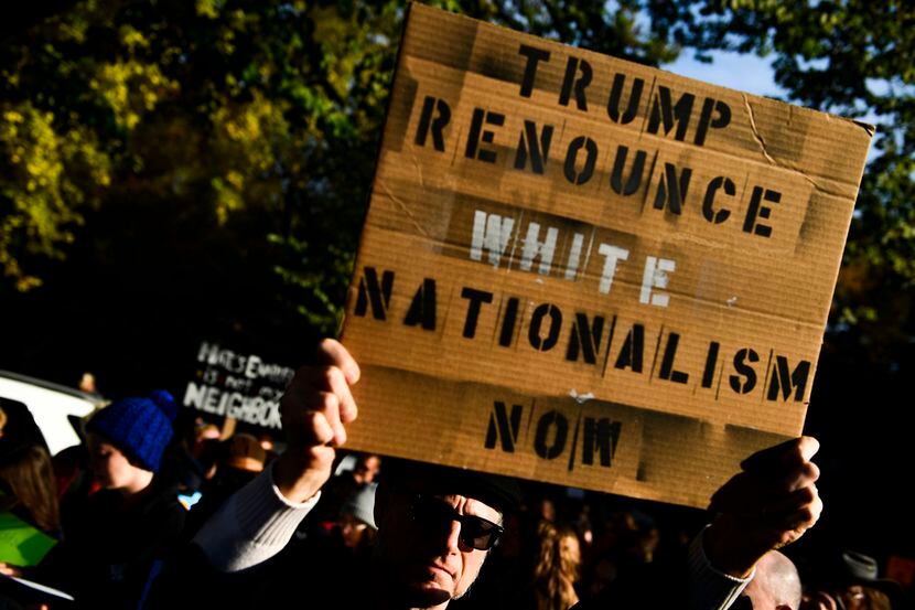 Una persona porta una pancarta en la que pide al presidente Donald Trump denunciar el...