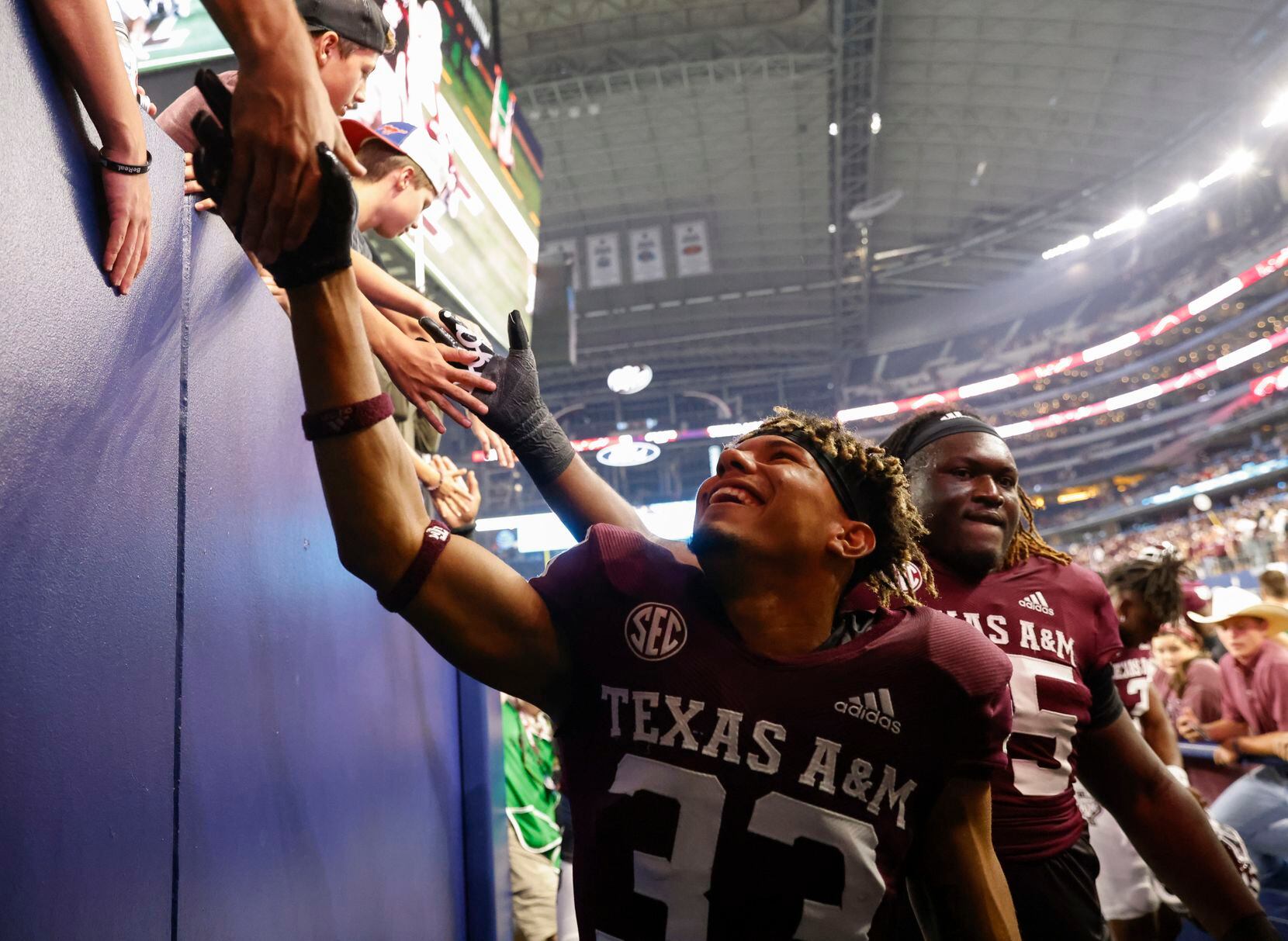 Texas A&M defensive back Jarred Kerr shakes hand with fans while entering the tunnel after...