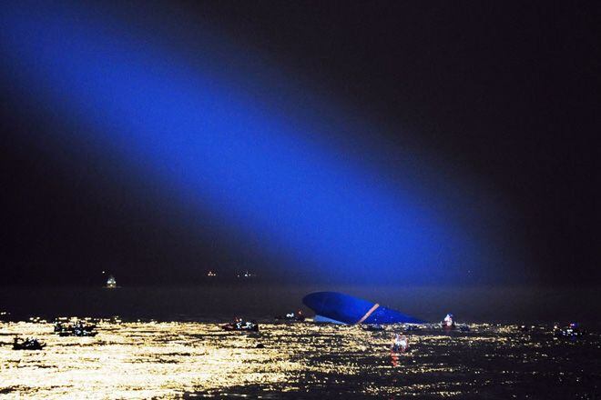 A blue searchlight from a South Korean Coast Guard helicopter provides illumination for...