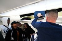 Passengers collect carryon baggage from overhead bins on a Southwest Airlines flight...