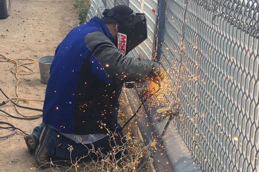Un soldador trabaja en una parte afectada de la valla fronteriza entre El Paso y Ciudad...