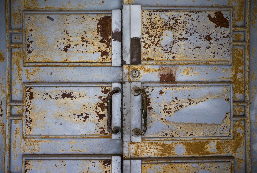 Chipped paint on metal doors is shown outside the historic Hall of State building on March...