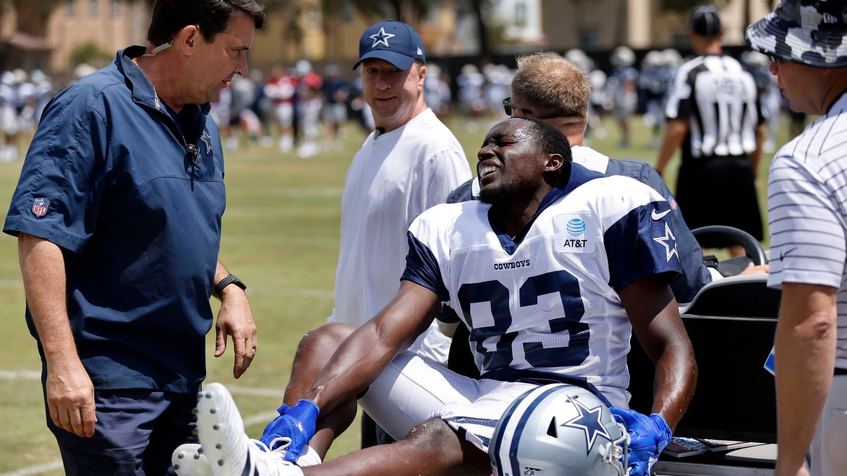 Dallas Cowboys wide receiver James Washington (83) holds his right foot as he is carted off...