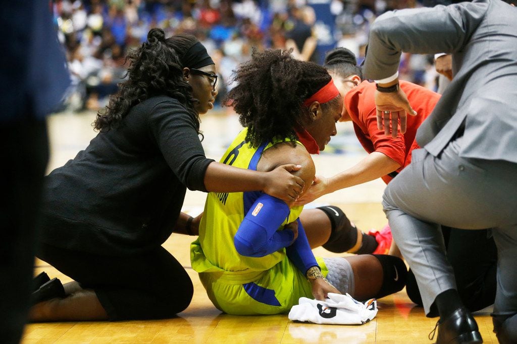 Dallas Wings Kayla Thornton (6) is gets assistance off the court during game against the Las...