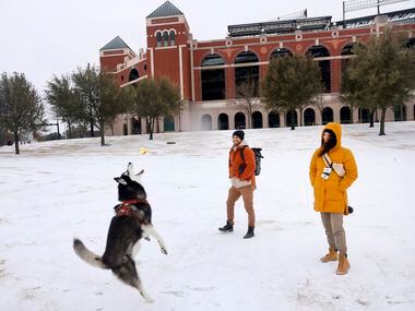 After a band of sleet dropped about 2 inches of sleet in Arlington, Eve Godat (right) and...