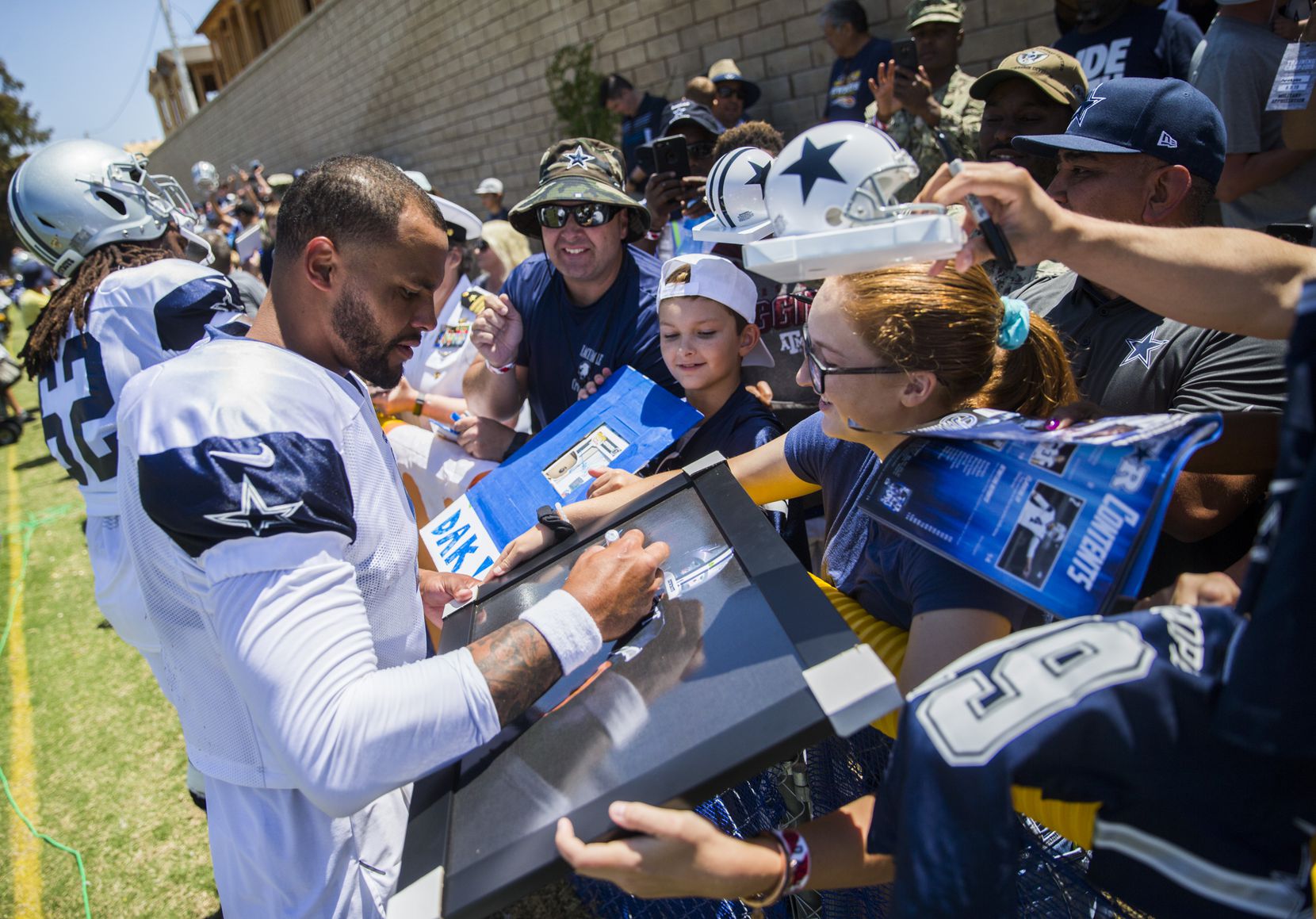 Dallas Cowboys quarterback Dak Prescott (4) signs autographs for fans during a morning...