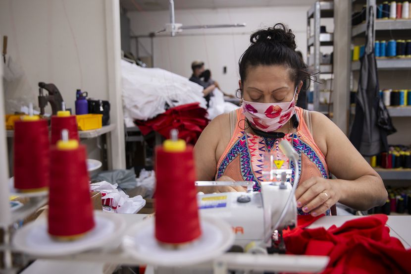 Seamstress Brenda Flores makes baby bloomers while wearing a mask at T&Q Cutting Services on...