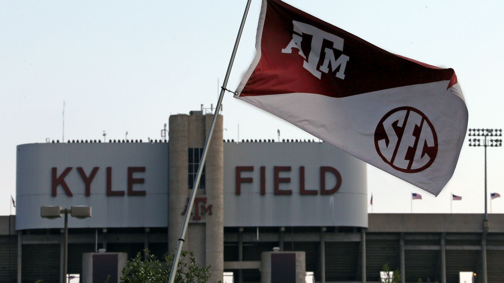 Texas A&M flags bearing the SEC logo bristle in the steady breeze outside Kyle Field before...