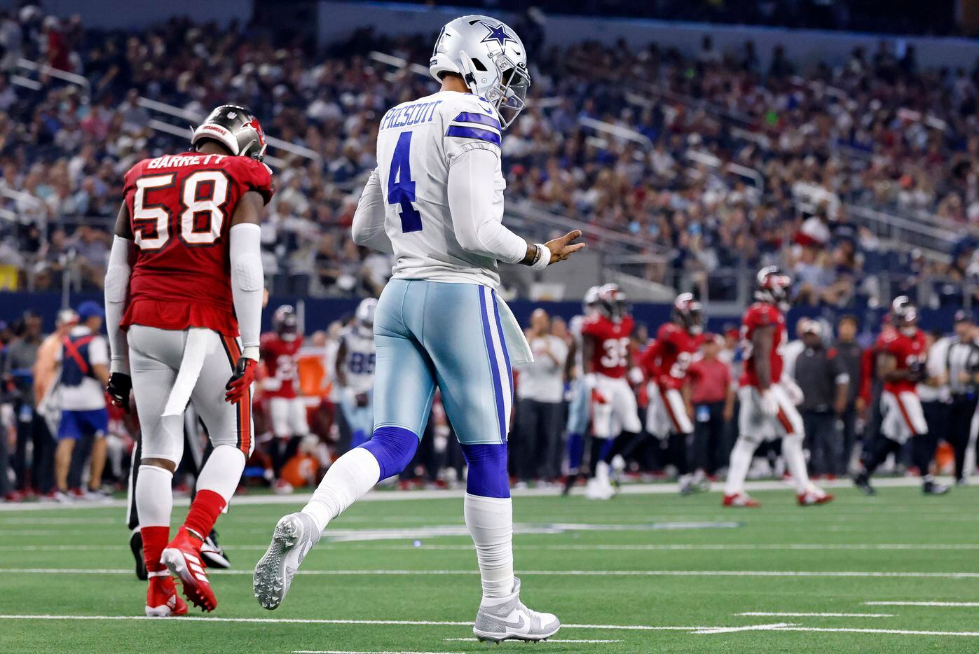 Dallas Cowboys quarterback Dak Prescott (4) looks at his throwing hand after hitting it on...