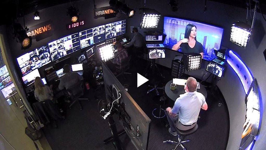 The NRA TV production team works nearby during a show hosted by Dallas-based anchor and...