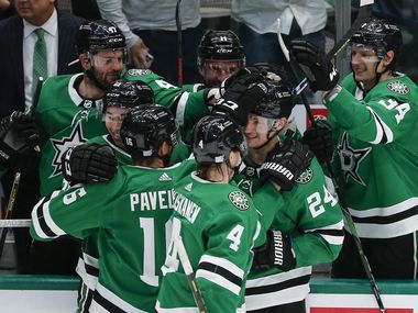 Dallas Stars forward Roope Hintz (24) is congratulated by teammates after scoring an empty net goal, for the hat trick, during the third period of an NHL hockey game against the Carolina Hurricanes in Dallas, Tuesday, November 30, 2021. Dallas won 4-1.