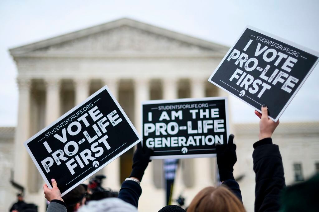 Anti-abortion advocates hold signs as they stand in front of the US Supreme Court while participating in the 47th annual March For Life in Washington, DC on January 24, 2020. - Activists gathered in the nation's capital for the annual event to mark the anniversary of the Supreme Court Roe v. Wade ruling that legalized abortion in 1973. (Photo by Roberto SCHMIDT / AFP) (Photo by ROBERTO SCHMIDT/AFP via Getty Images)