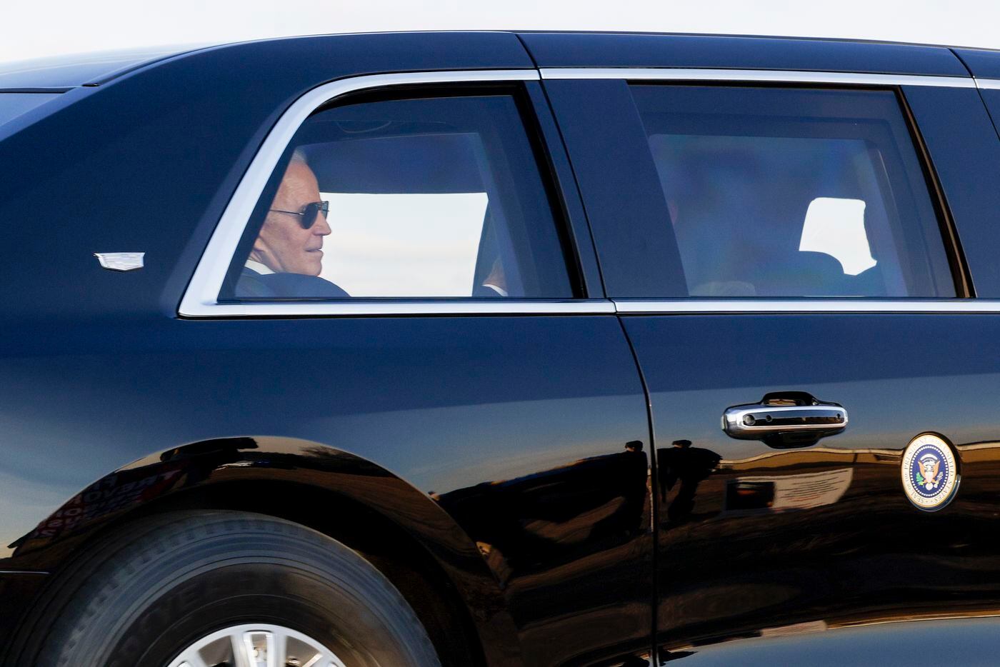 President Joe Biden rides past the family of former Marine Trevor Reed near the Tarrant...