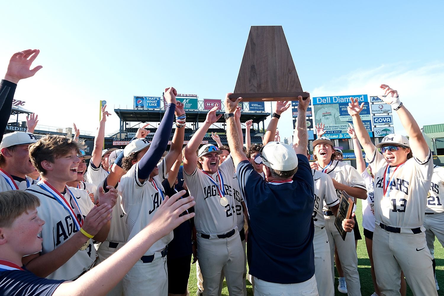 Flower Mound coach, Danny Wallace, lifts the championship trophy as he celebrates with the...
