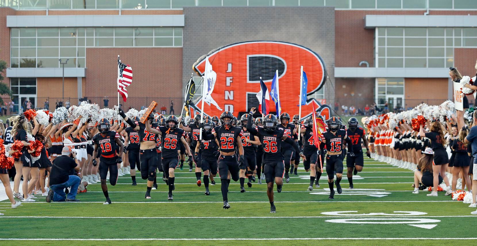 The Rockwall Yellowjackets take the field before the first half of a high school football...