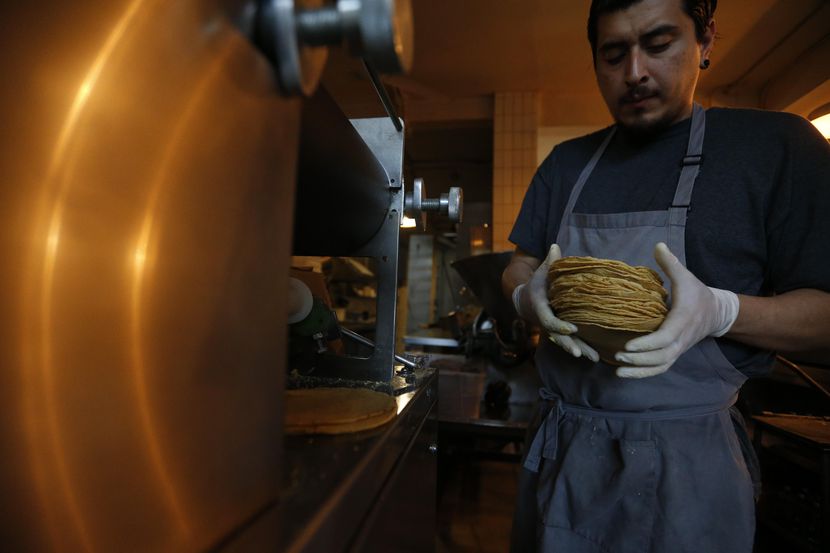 Jesús Saldivar toma tortillas recien salidas de la máquina del Molino El Pujol, en la Ciudad...