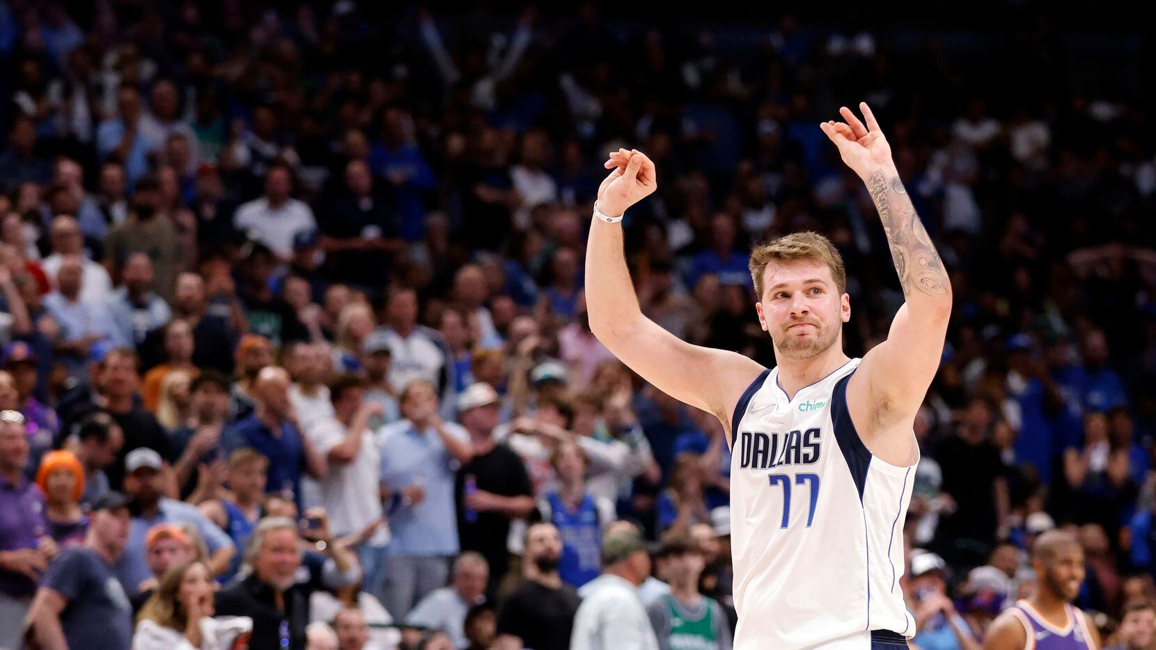 Dallas Mavericks guard Luka Doncic (77) raises his hands as he walks to the bench during the...