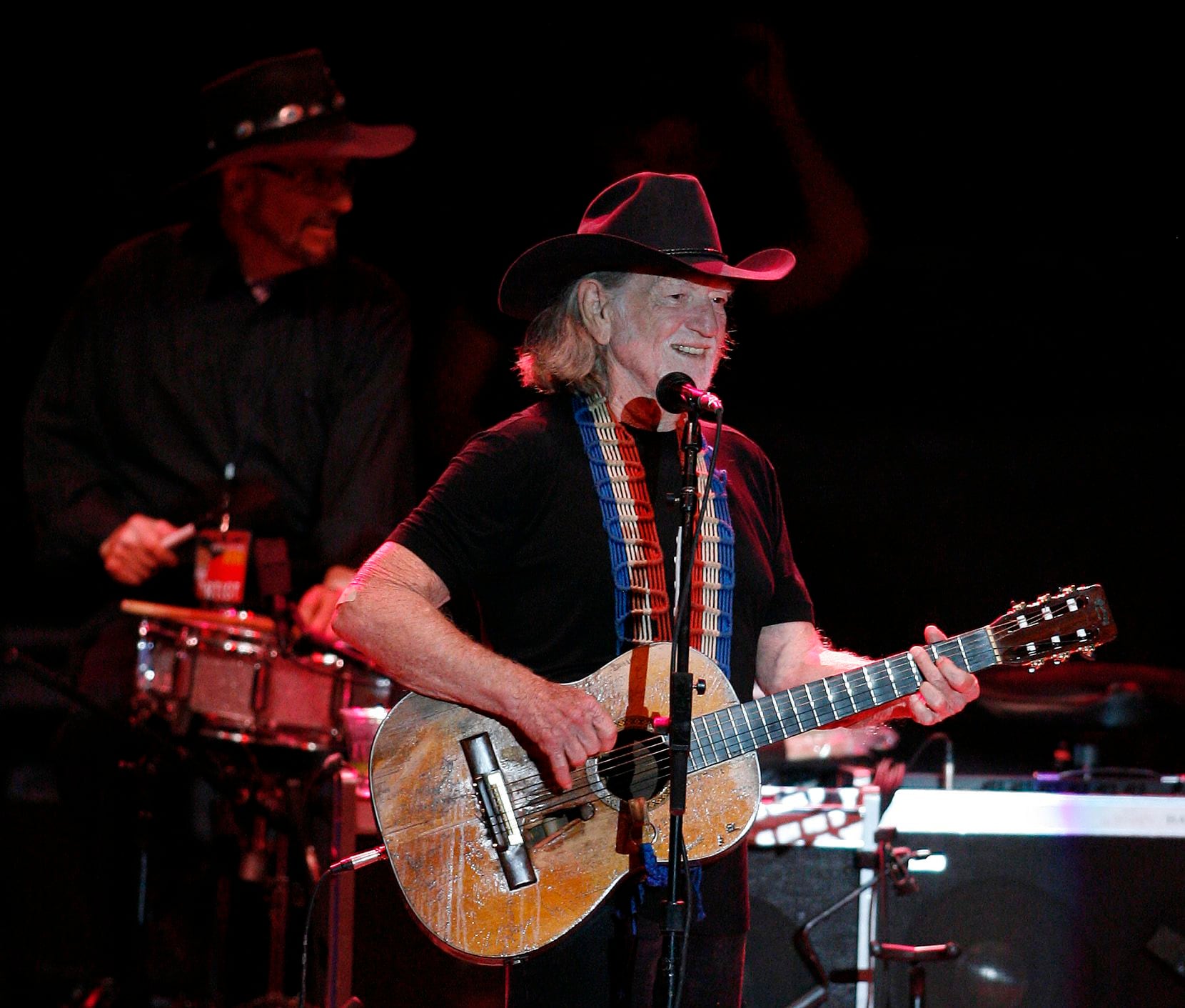 Willie Nelson plays "Me and Paul" while drummer Paul English plays in the background during...