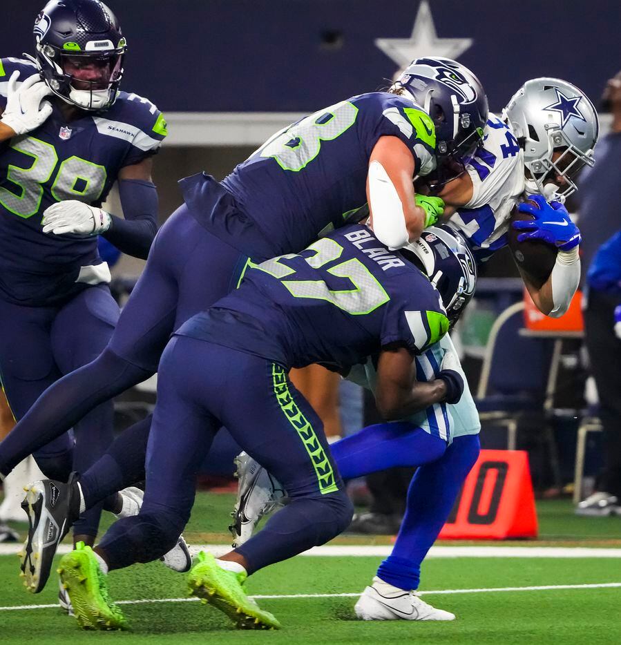 Dallas Cowboys running back Malik Davis (34) is pulled down by Seattle Seahawks safety...