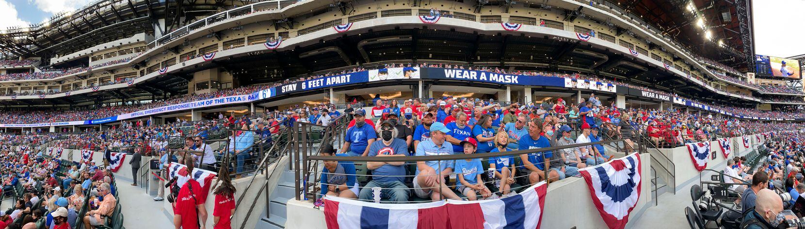 In a panoramic view, the The Texas Rangers baseball team reminded a nearly sold-out crowd to practice COVID-19 protocols during Opening Day at Globe Life Field in Arlington, Monday, April 5, 2021. The Texas Rangers were facing the Toronto Blue Jays in their home opener. The Rangers lost, 6-4. (Tom Fox/The Dallas Morning News)