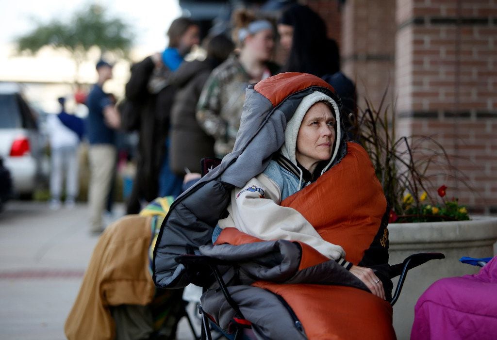 Vicki Ireland keeps warm as she waits for Tiff's Treats to open in Allen, Texas, Saturday,...