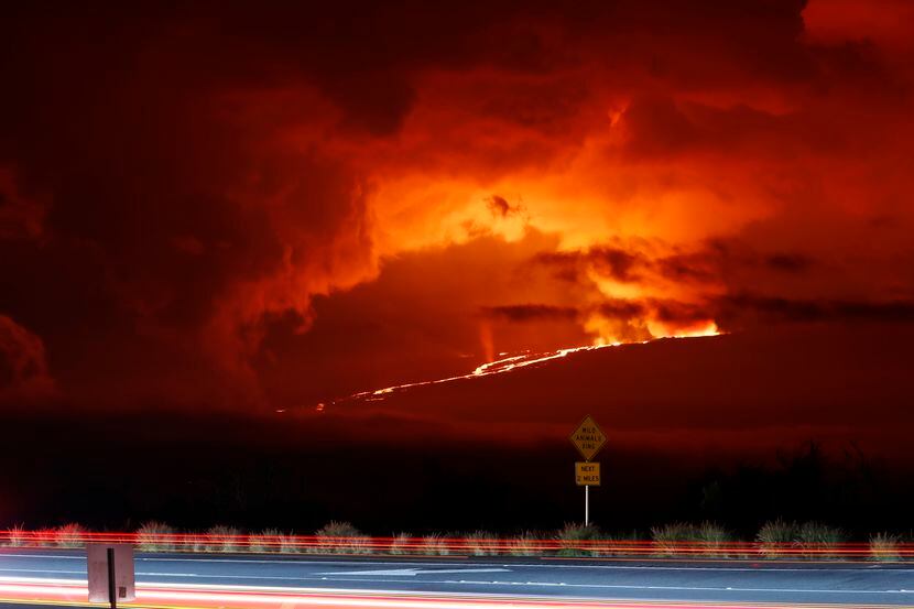 En esta fotogafía automóviles pasan frente al volcán Mauna Loa en erupción, el lunes 28 de...