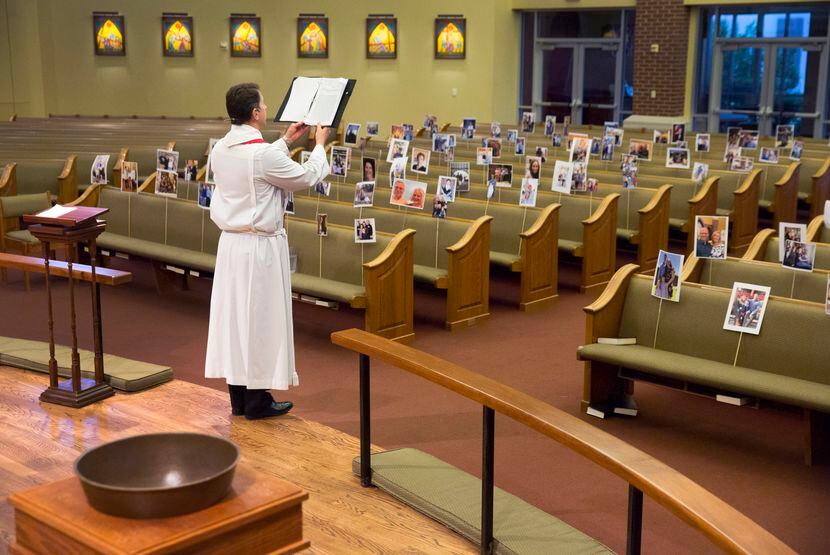 Before a sanctuary full of parishioners' photos, Father Clayton Elder delivers his Holy...