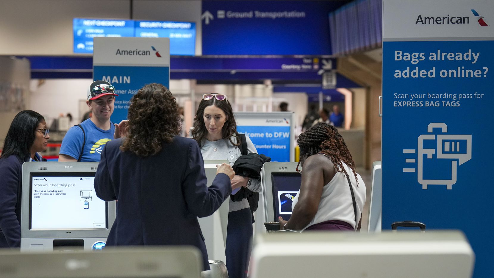 Passengers check baggage with American Airlines agents at Terminal C at DFW International...